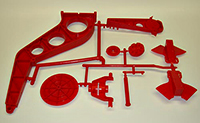 Red family mold shot with several parts still on the runner